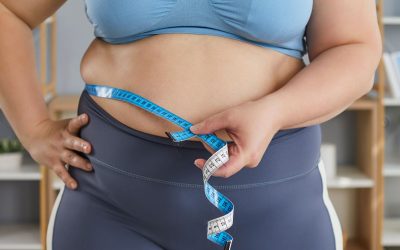 mulher com obesidade a medir cintura vitamina d